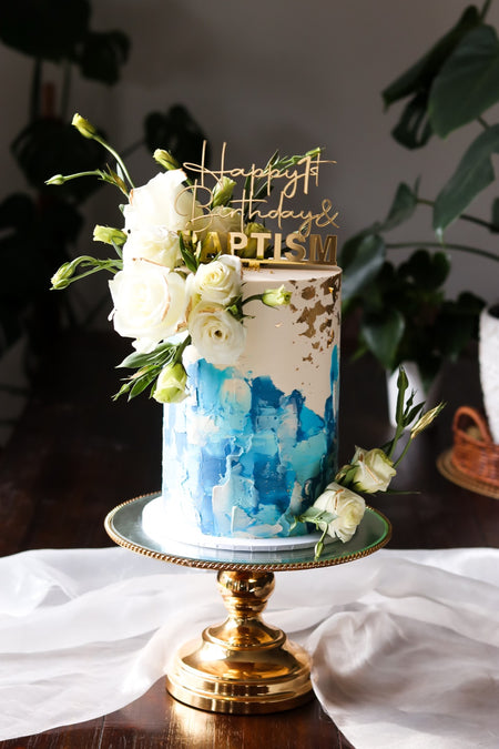 Blue and white watercolour baptism cake with fresh white roses and gold leaf