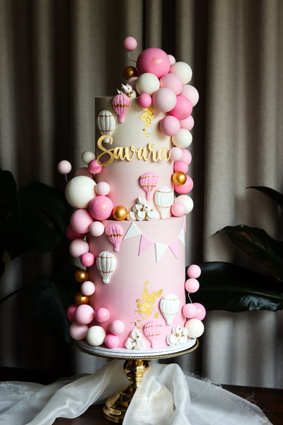 Two tier pink hot air balloon cake with a pink and gold balloon garland