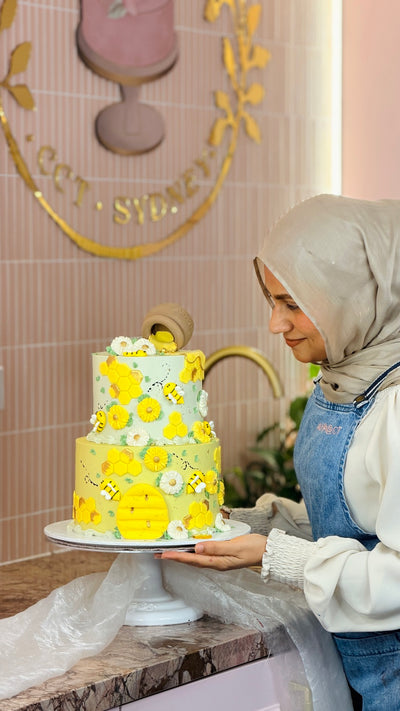 Bumblebee and daisy two-tier buttercream cake